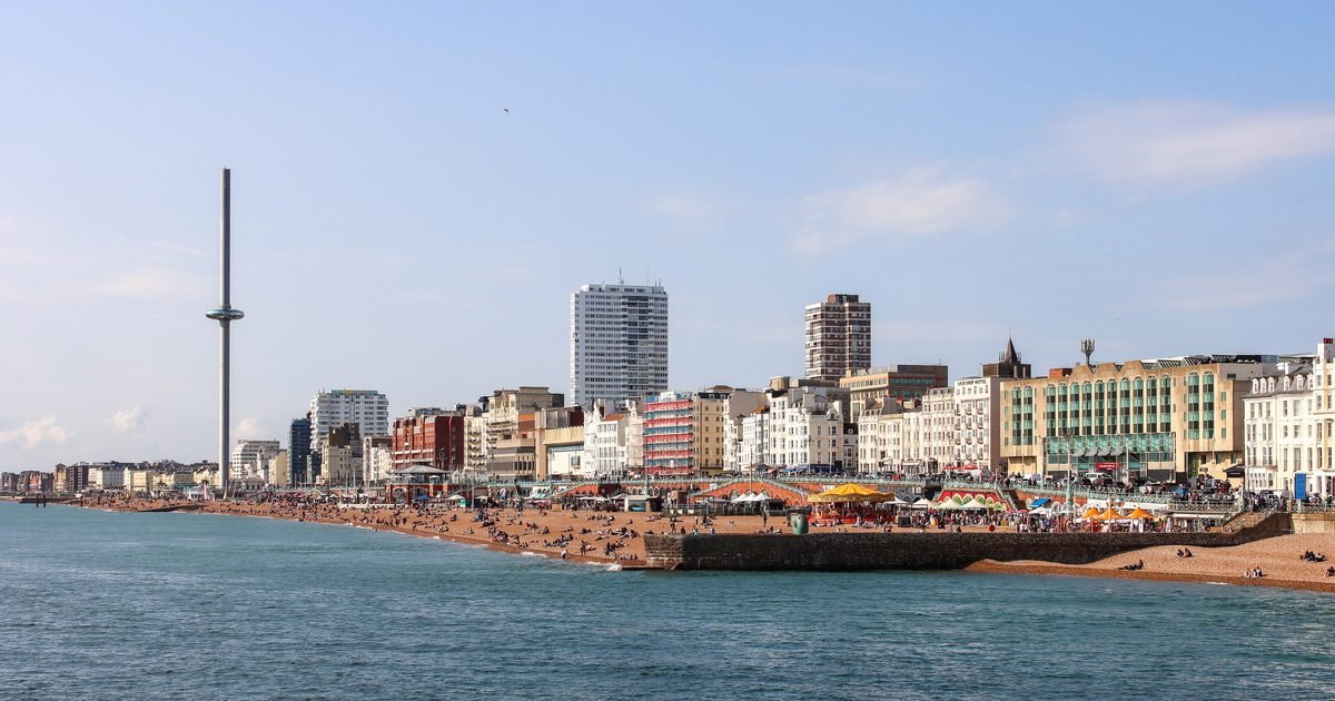 Brighton seafront at sunset with the West Pier silhouette and beachfront promenade with i360 in the distance